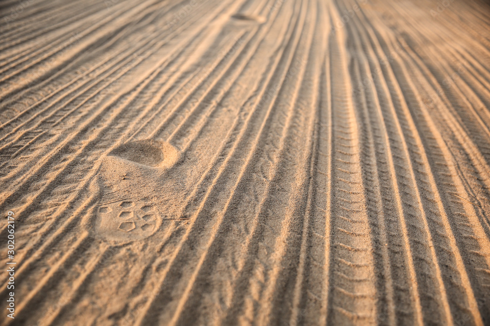 tire tracks on the sand. background of tyre tracks and footprints tire tracks on the sand. background of tyre tracks and footprints