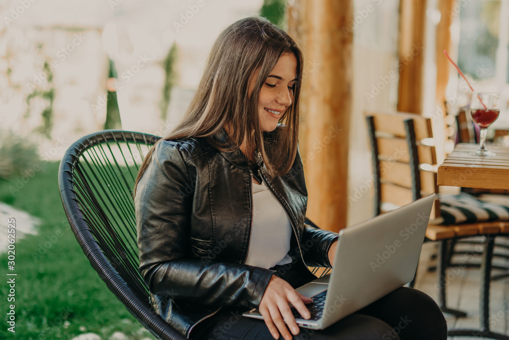Attractive woman sitting in modern coffee shop and working on laptop Attractive woman sitting in modern coffee shop and working on laptop