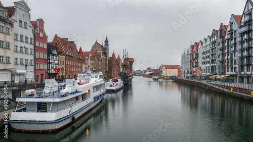 City Gdansk in Poland with the oldest medival port crane called Zuraw and a promenade along the riverbank of Motlawa River. November.