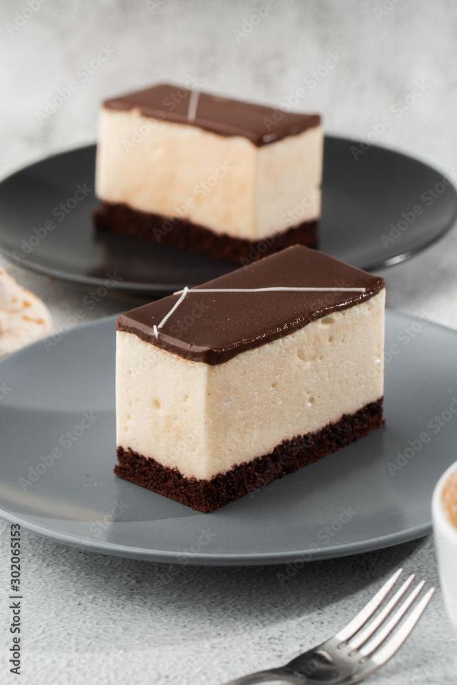 Piece of cake with souffle Bird's milk , biscuit, mousse and dark chocolate on a dark plate, white souffle cake. Menu for bakery. cafe menu. Delicious and sweet dessert at cafe restaurant.Vertical Piece of cake with souffle Bird's milk , biscuit, mousse and dark chocolate on a dark plate, white souffle cake. Menu for bakery. cafe menu. Delicious and sweet dessert at cafe restaurant.Vertical