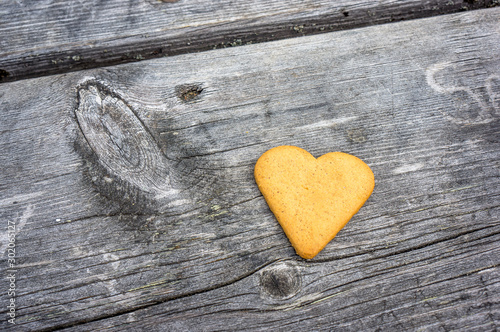 Heart-shaped cookie lies on a wooden table