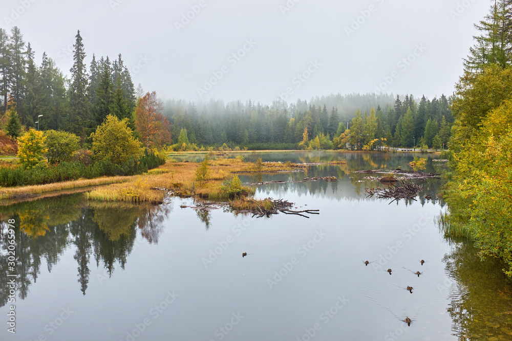 The autumn new Strbske pleso lake with peaks , clouds and reflection on the water in Hight Tatras National park , Slovakia The autumn new Strbske pleso lake with peaks , clouds and reflection on the water in Hight Tatras National park , Slovakia