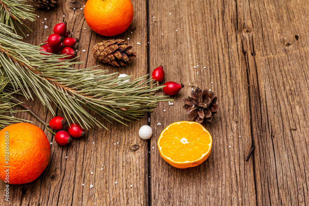 Spirit Christmas background. Fresh mandarins, dog-rose berries, candies, pine branches and cones, artificial snow Spirit Christmas background. Fresh mandarins, dog-rose berries, candies, pine branches and cones, artificial snow