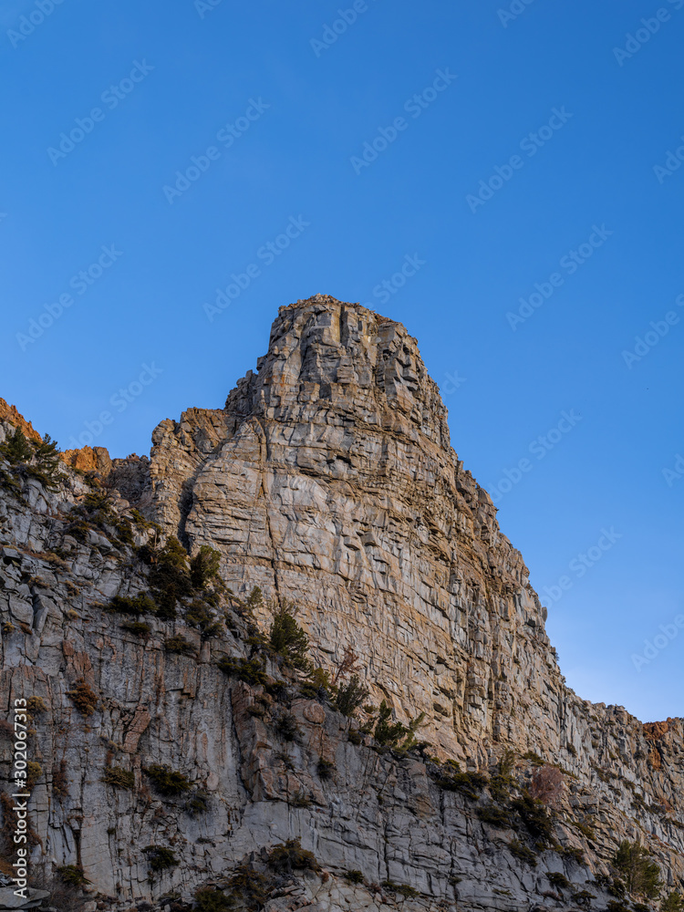 Naklejka premium Rugged granite mountain peak in Yosemite National Park with a vibrant blue sky during autumn