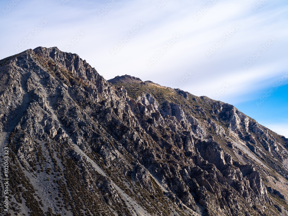 Rugged granite mountain peak in Yosemite National Park with a vibrant blue sky during autumn