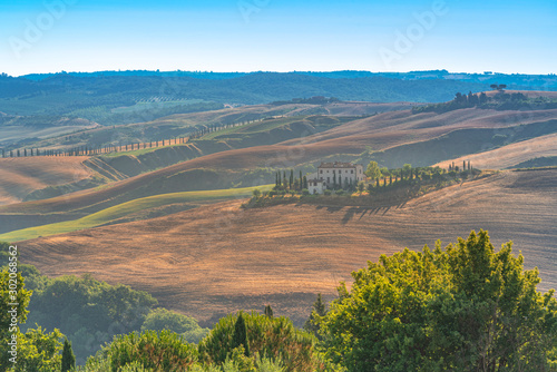 View of rural landscape with isolated farm house in the hills. Travel destination Tuscany, Italy