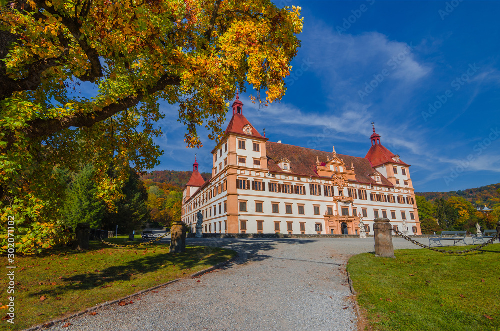 Obraz premium Colorful autumn colors, bright blue sky in the park and Eggenberg Palace in Graz, Styria region, Austria