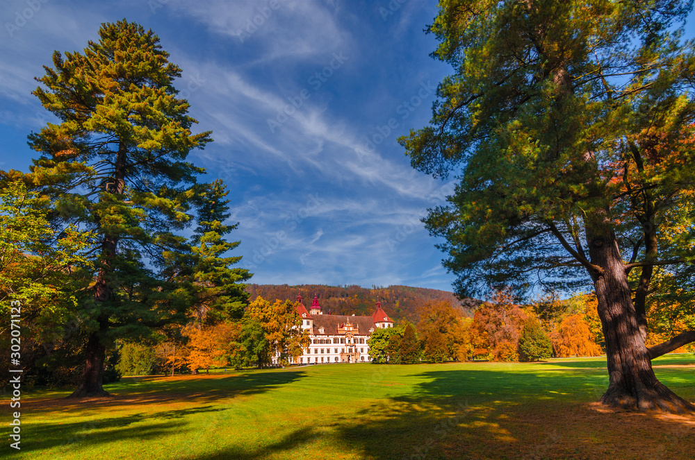 Colorful autumn colors, bright blue sky in the park and Eggenberg Palace in Graz, Styria region, Austria