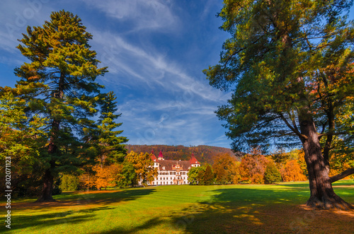 Colorful autumn colors  bright blue sky in the park and Eggenberg Palace in Graz  Styria region  Austria