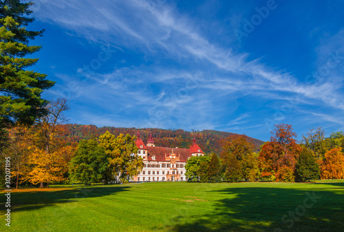 Colorful autumn colors, bright blue sky in the park and Eggenberg Palace in Graz, Styria region, Austria photo