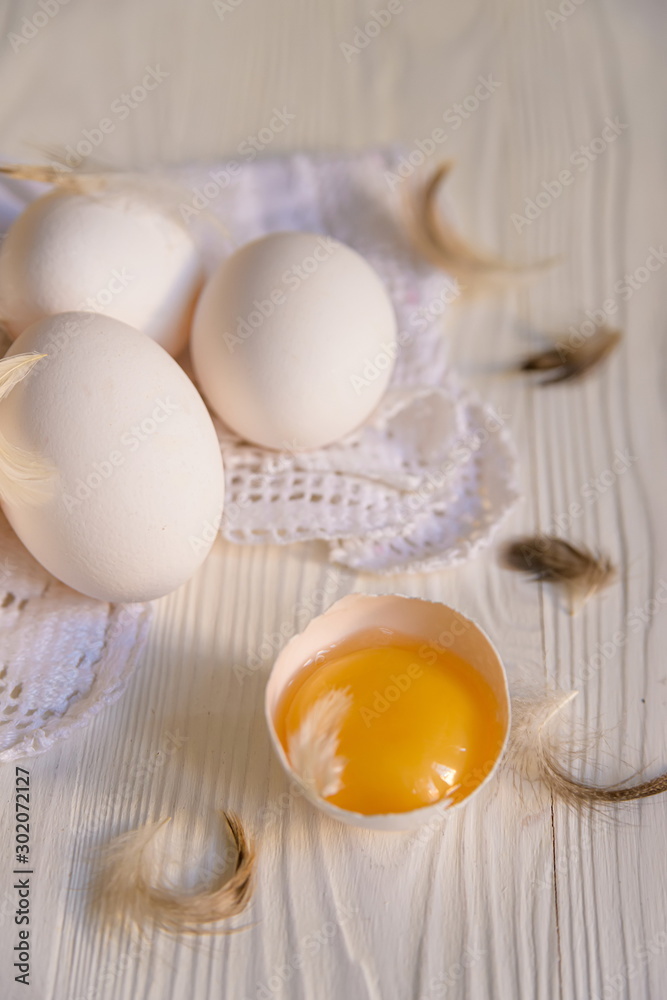 Fresh farm eggs and feathers on a wooden rustic background. Close-up with a shallow depth of field. Fresh farm eggs and feathers on a wooden rustic background. Close-up with a shallow depth of field.