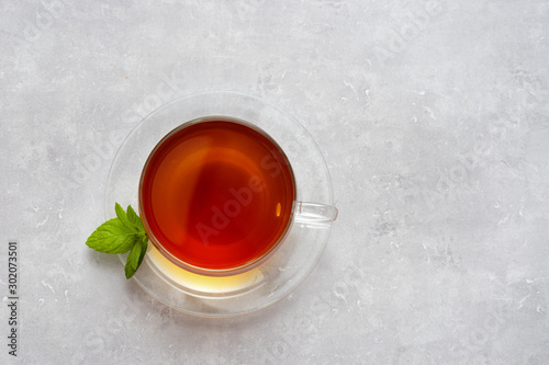 Top view of glass cup with tea on light background