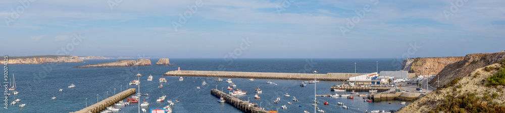 Panorama of Sagres Harbour, Algarve, Portugal, harbour boats and the harbour wall with cliffs and rocks behind