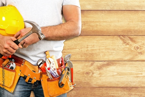 Quadro em tela Young man worker with tool belt and helmet