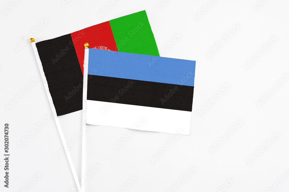 Estonia and Afghanistan stick flags on white background. High quality fabric, miniature national flag. Peaceful global concept.White floor for copy space. Estonia and Afghanistan stick flags on white background. High quality fabric, miniature national flag. Peaceful global concept.White floor for copy space.