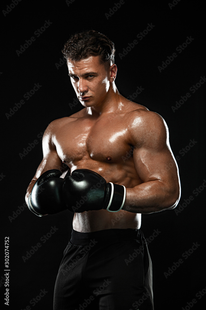 Boxer, man fighting or posing in gloves on black background. Fitness and boxing concept. Individual sports recreation.