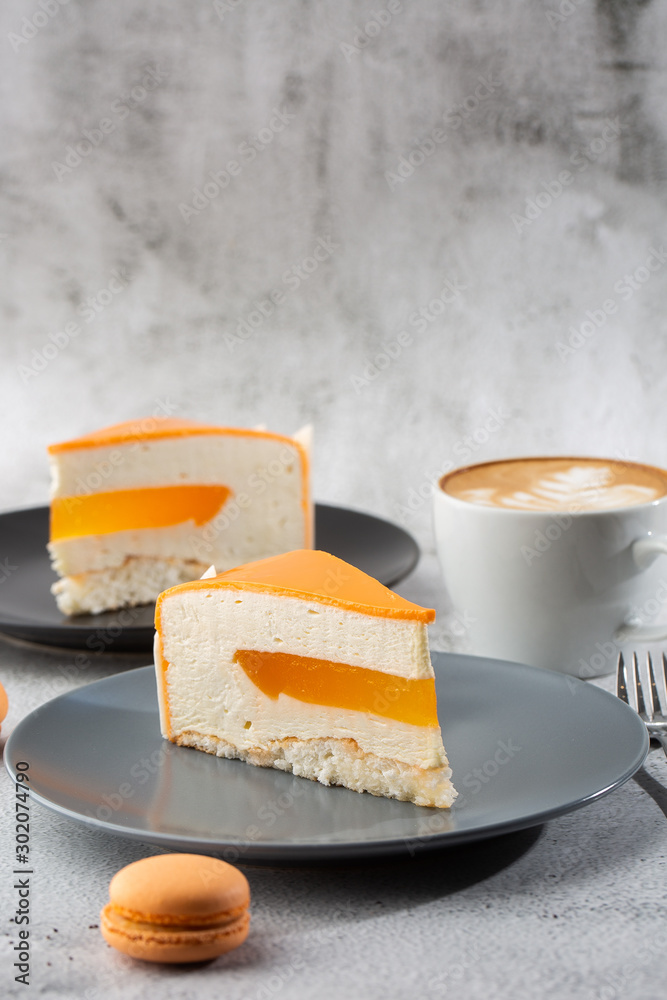 Elegant Cake with coconut, passion fruit, mangoes and bananas, covered with chocolate glaze. Slice of orange layered cake on marble background. Wallpaper for pastry cafe or cafe menu. vertical.