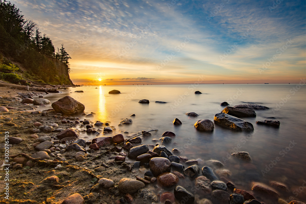 Fototapeta premium Wschód słońca na plaży w Gdyni z klifem Orłowskim w tle, Morze Bałtyckie, Polska