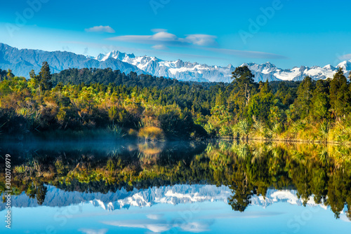 Mirror image reflections of the snow capped Southern Alps on Okarito Lagoon on the West Coast