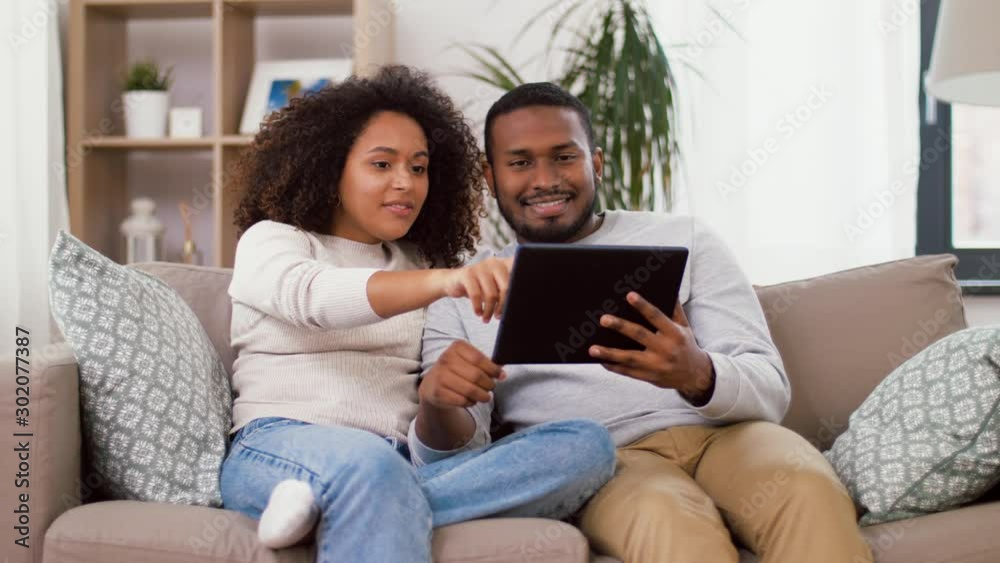 technology, internet and people concept - happy african american couple with tablet computer at home technology, internet and people concept - happy african american couple with tablet computer at home