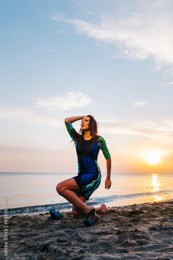 An attractive sexy model is posing at beach, sunset time