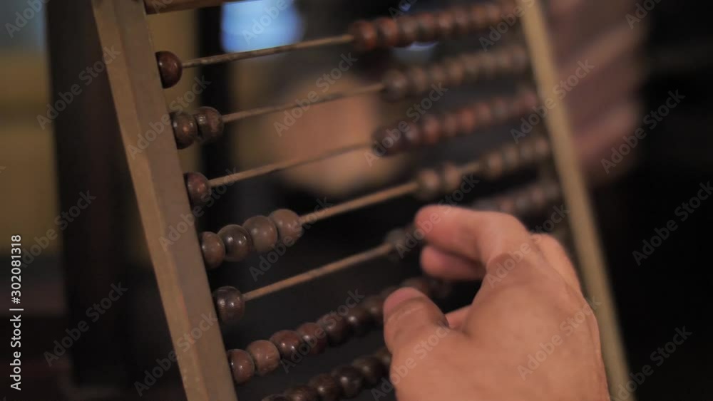 Man using vintage wooden abacus 
