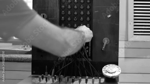 Close up on male hand using vintage telephone exchange. Black and white shot