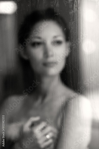Junge Frau blickt durch ein Fenster aus einem Hamam