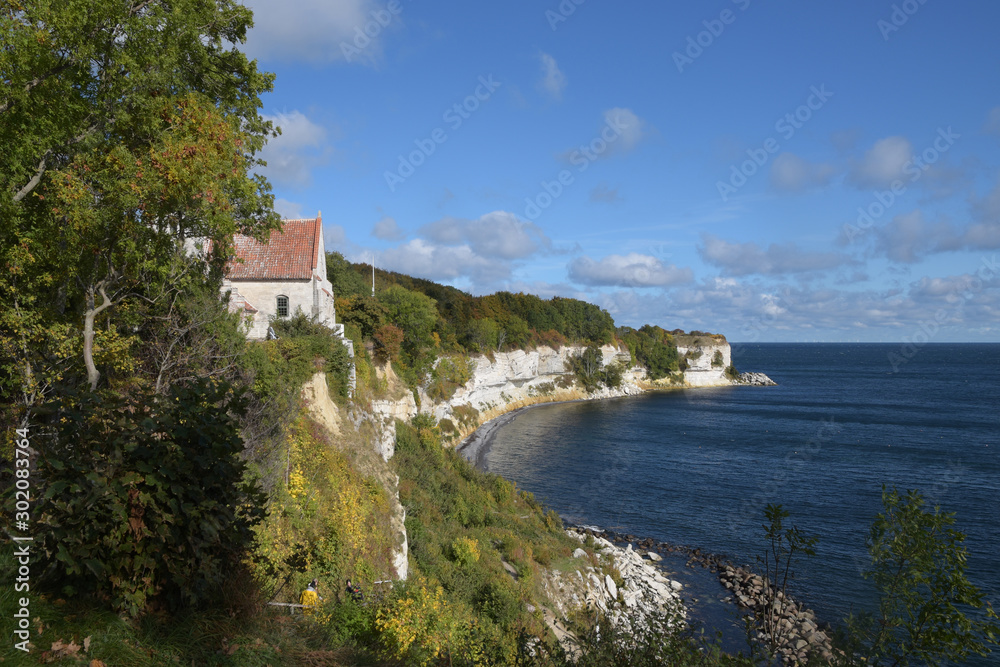 Old church in Hoejerup, tourist attraction at Stevns Klint the chalk cliff on the Danish island Zealand in the Baltic Sea, blue sky with copy space