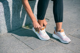 Legs and woman touching sneakers stock photo