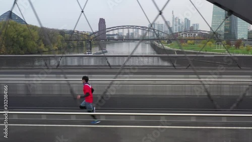 Wallpaper Mural The young sportsman does warm-up exercises in late autumn in the city of Frankfurt. 11.11.2019 Frankfurt am Main, Germany. Torontodigital.ca