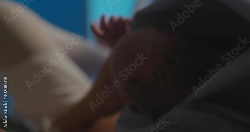 Authentic shot of an young woman is crying of happiness emotions by a first meet of her newborn baby after giving a birth in a delivery room of a hospital.