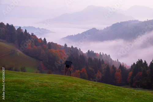 Sveti Tomaz Church on a hilltop in a valley with fog at sunrise in autumn, near Skofja Loka photo