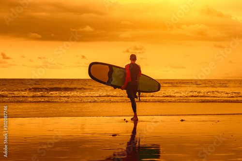 a man enters the water for surfing.