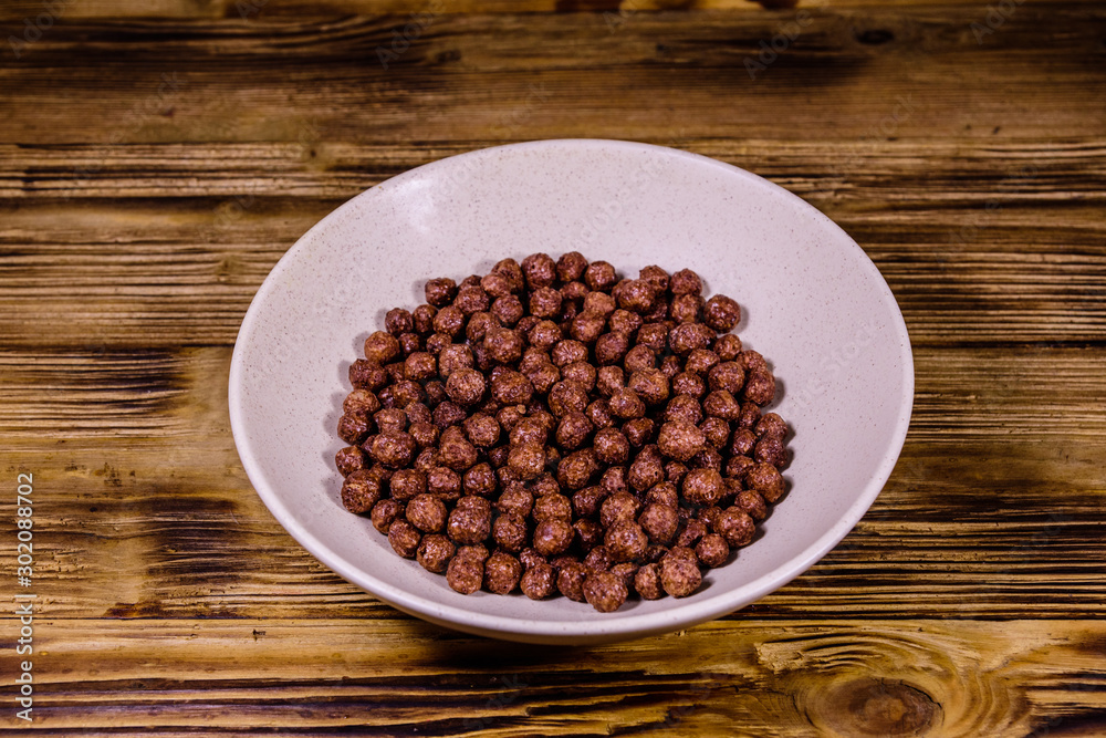 Ceramic plate with chocolate cereal balls on wooden table Ceramic plate with chocolate cereal balls on wooden table