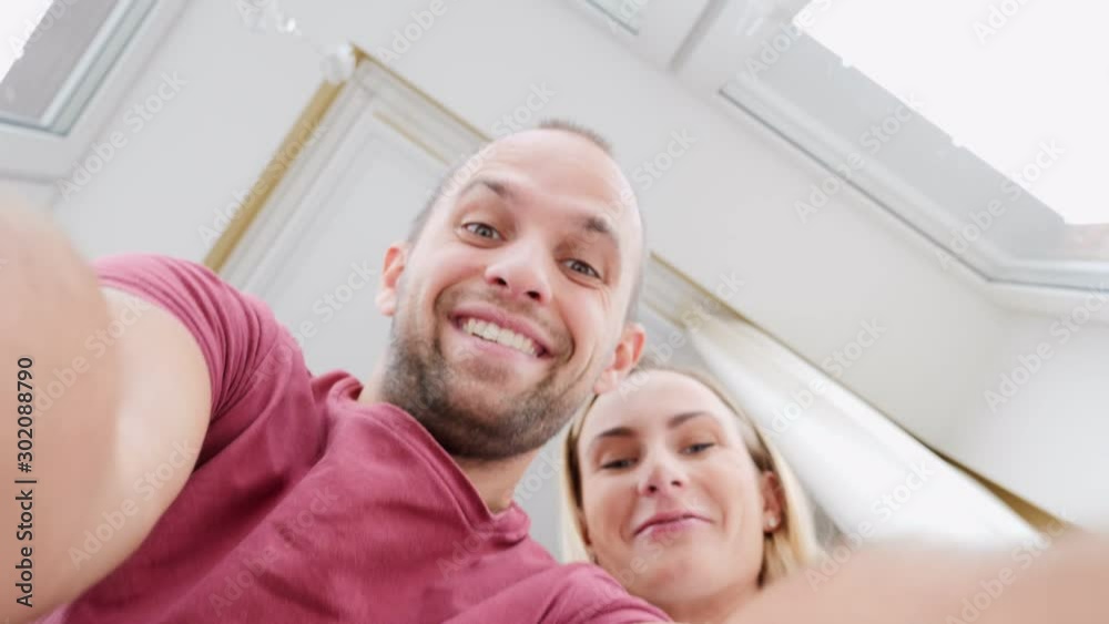 Young happy couple opening cardboard box after relocation and looking inside Young happy couple opening cardboard box after relocation and looking inside