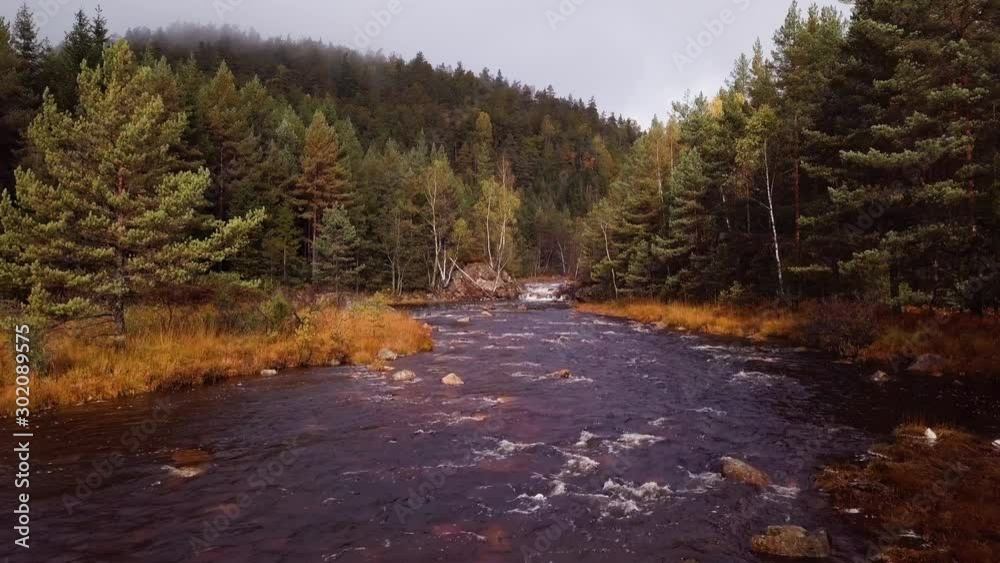 Aerial, drone shot, low over rapids, at the Tovdalselva river, in middle of hills and foliage forest, on a foggy, autumn day, in Flakk, Aust-Agder, South Norway Aerial, drone shot, low over rapids, at the Tovdalselva river, in middle of hills and foliage forest, on a foggy, autumn day, in Flakk, Aust-Agder, South Norway