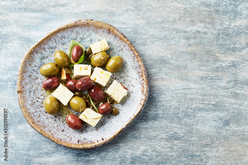 Green and kalamata olives, capers and feta cheese on rustic wooden background. Healthy Snack Idea. Top view. Copy space. 