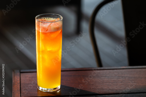 fresh orange and peach alcohol cocktail outside at a restaurant interior 