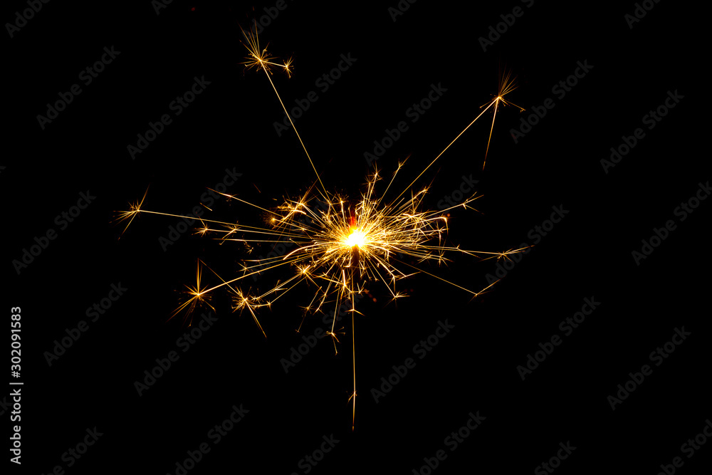 burning sparkler and flying sparks on a black background, festive sparkler