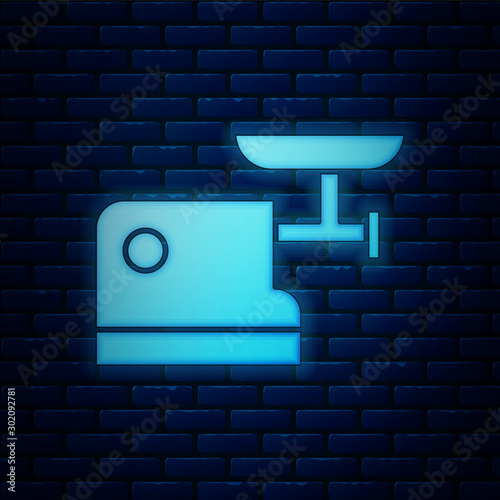 Glowing neon Kitchen meat grinder icon isolated on brick wall background. Vector Illustration