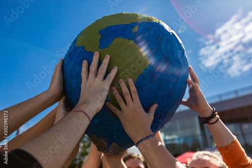 Close up of group of hands holding and protecting terra globe with lens flares. Activist expresion at protest in Saint Jerome photo