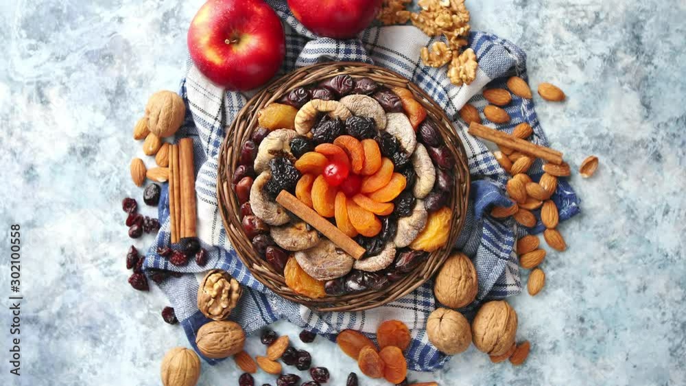 Composition of dried fruits and nuts in small wicker bowl placed on stone table