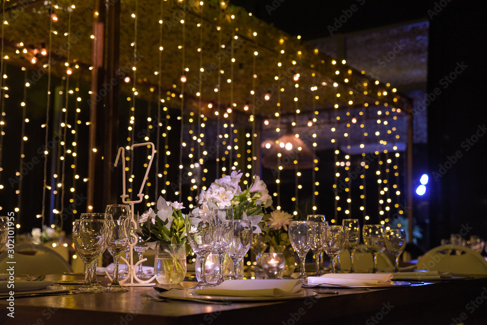 Mesa navideña con plantas, velas, copas de vino y flores. Mesa navideña con plantas, velas, copas de vino y flores.