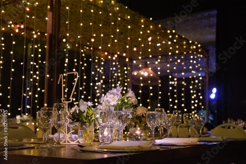 Mesa navide  a con plantas  velas  copas de vino y flores.