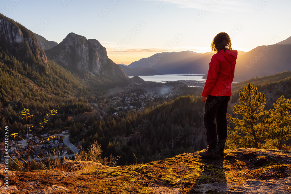 Fototapeta premium Adventurous Girl Hiking in the mountains during a sunny Autumn Sunset. Taken Squamish, North of Vancouver, British Columbia, Canada.