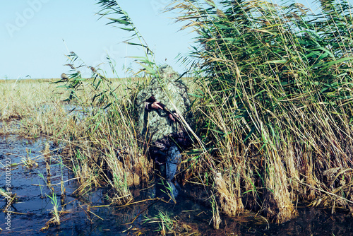 excellent hunter disguise - a lone hunter hid in the reeds awaiting prey
