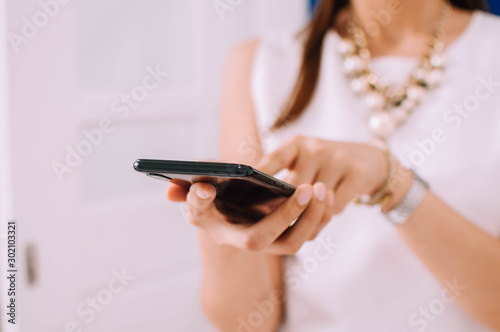 A young woman is using a smartphone indoor