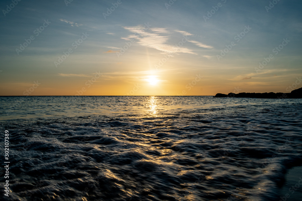 Naklejka premium Water Rolling onto Shore during Sunset at Playa Porto Marie, Curaçao