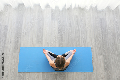 Young woman practicing yoga...